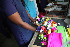 A young woman who survived sex trafficking in India shows paper flowers she made as part of a rehabilitation programme. Credits: Laura Sheahen/CRS