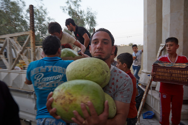 An Iraqi refugee helps unload food to community center's kitchen of  St John the Baptist Church. Photo by Alexander Buehler/Caritas 