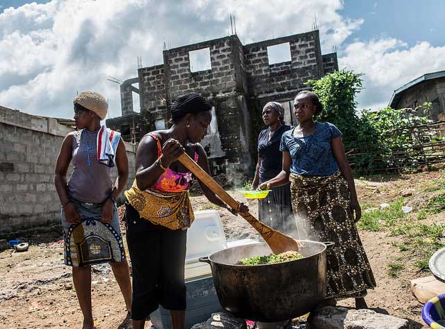   Women prepare a meal of rice and chicken for children in Allen Town. Sierra Leone. 