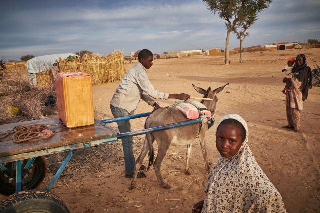 A boy delivers water at a camp of displaced people in the neighbourhood of Chateau, Diffa, Niger. Photo by Sam Phelps/Caritas 