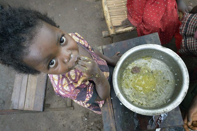 Two-year old Jennifer Angel enjoys the last of her family's meal in a camp for for than 5,000 displaced people in Riimenze, in South Sudan's Gbudwe State, what was formerly Western Equatoria. Photo by Paul Jeffrey/Caritas