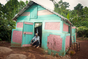 A man in front of his house, a part of local reconstruction and rehabilitation of traditional houses project. Credits: Secours Catholique