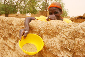 A woman holds a bowl of millet husks in Toudoun Jaka, Niger. In 2010, Nigeriens ate millet husks--normally used to feed livestock--because they lacked food. Credits: Lane Hartill/CRS
