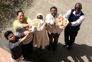Caritas leaders participating in a "Food for All" meeting in Rome this week raise up bread. Credit: Sheahen/Caritas