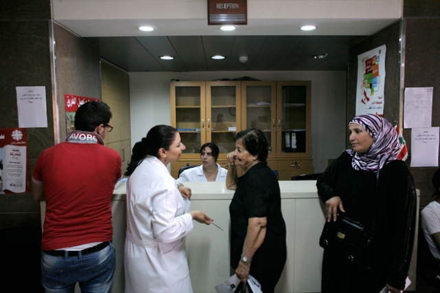 Fatima Ali (a la derecha), esperando su turno en el Centro médico-social St. Michel, financiado por Cáritas, el 20 de junio de 2014 en Sed El Baouchrieh, en Beirut. Foto: Matthieu Alexandre/Cáritas.