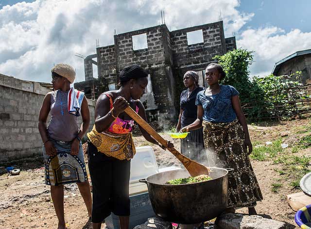 Women prepare a meal of rice and chicken for children in Allen Town. Sierra Leone.