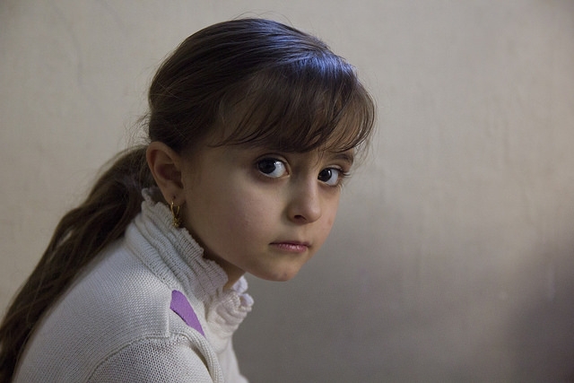 Malak, 5, fled Iraq with her family three months ago.  Her mother Nada Kariakos, 36, explains that they feared reprisals against Christians. Tabitha Ross/Caritas