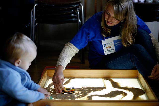 Valentina Bachynska (R), 21, junior coordinator at the Caritas Kiev Center, playing with Aristarkh, a 2 yo boy. MATTHIEU ALEXANDRE / CARITAS INTERNATIONALIS
