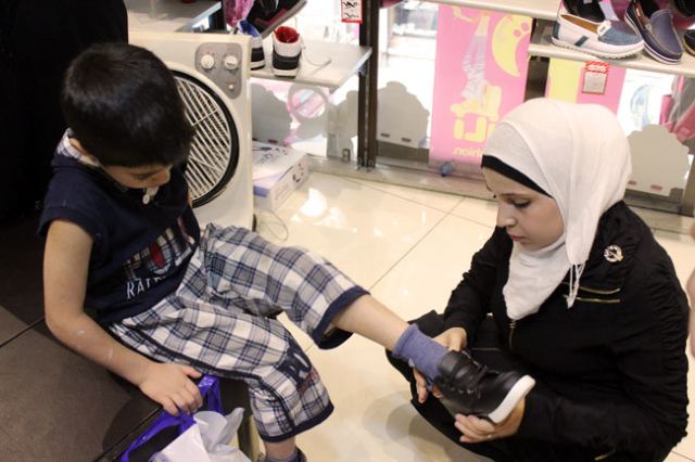 With Caritas voucher, Walaa bought new shoes for her son
